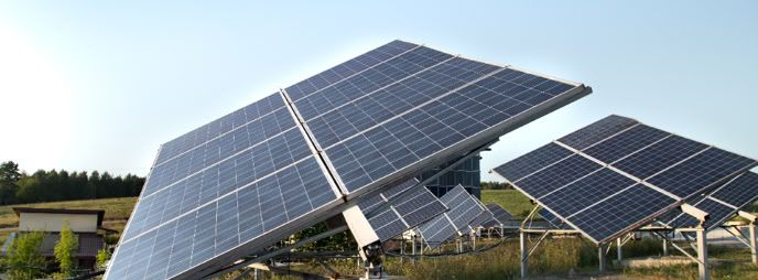 Solar panels installed on a grassy field under a clear sky.