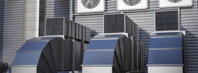 Industrial ventilation system with large ducts and fans on a building exterior.