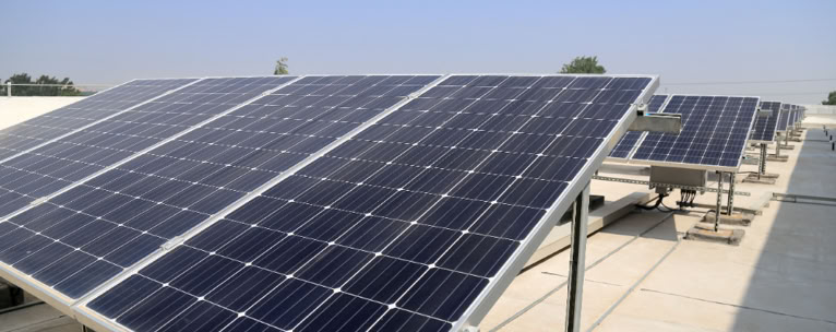 Solar panels installed on a rooftop under a clear blue sky.